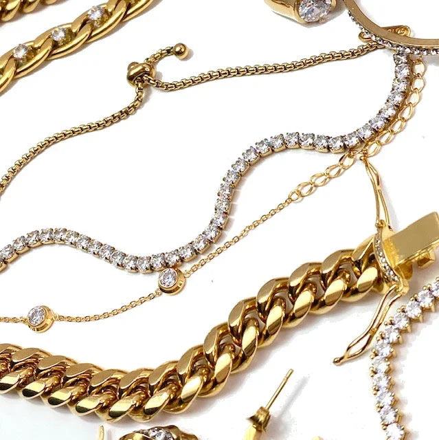 close-up of gold and diamond jewelry including chain bracelets and delicate diamond-studded necklaces